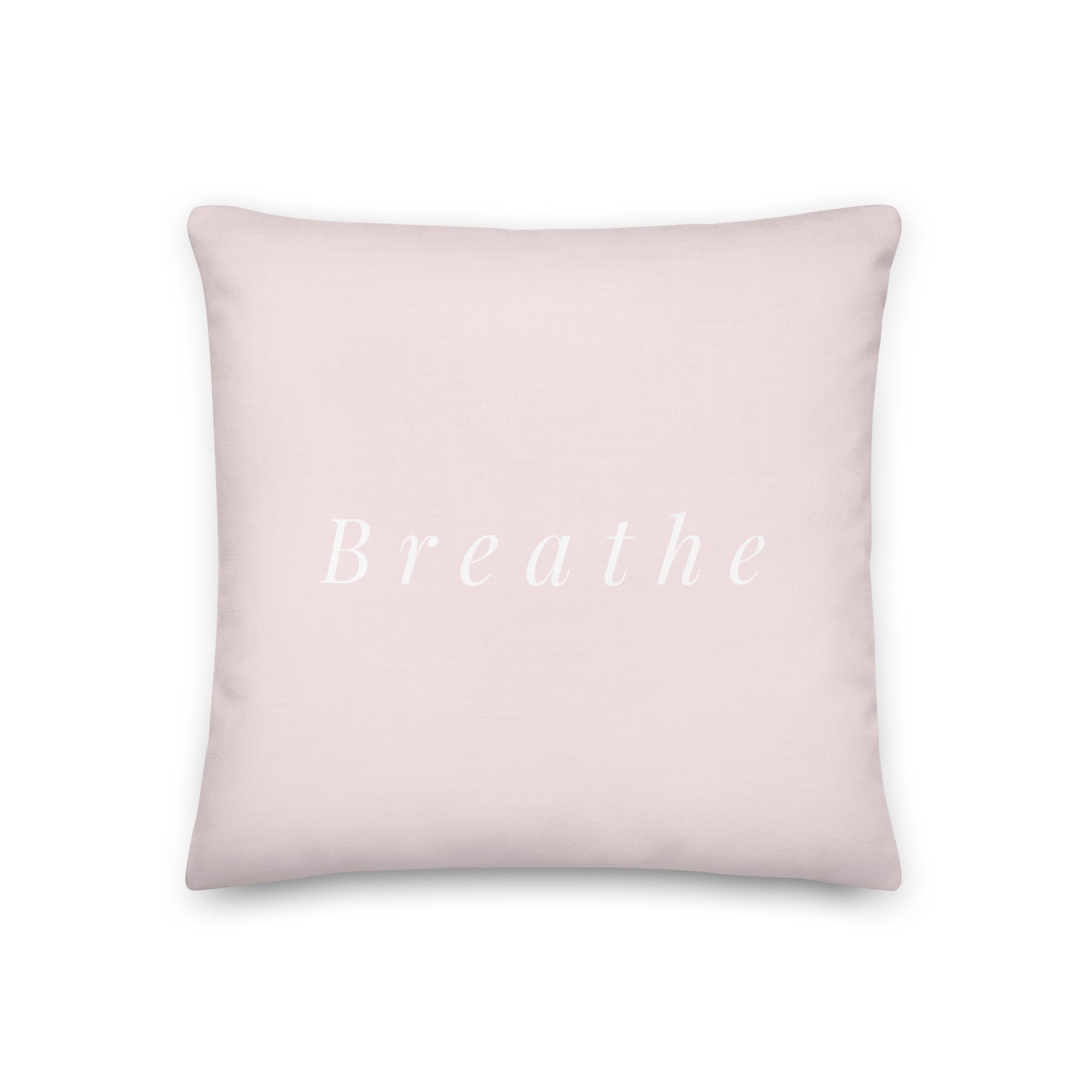 Blush pink pillow back with elegant serif text “Breathe” in white – minimalist mindful message design