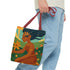 Model with Modern Folklore Tote – red straps, expressive blooming field design | Tragetasche mit rotem Henkel und floraler Motivik, getragen am Arm